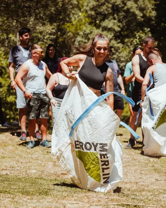 Carrera de sacos en el césped con el equipo animando