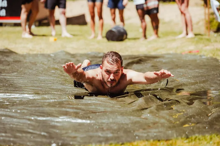 Un chico se tira en plancha por el tobogán de agua