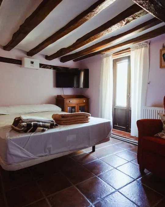 Habitación de una de las casas de piedra, con vigas de madera