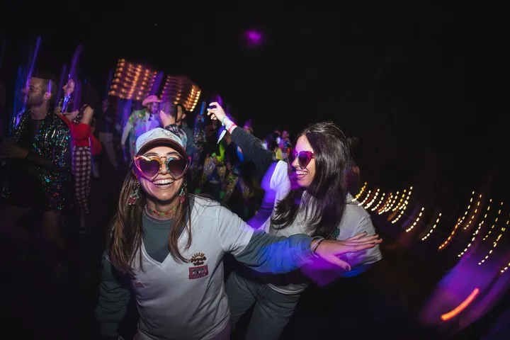 Dos amigas bailan con gafas de colores en la fiesta del jueves