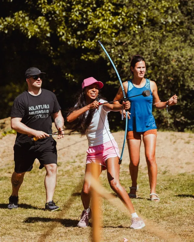 Partida de archery tag: arcos y flechas de espuma en el prado