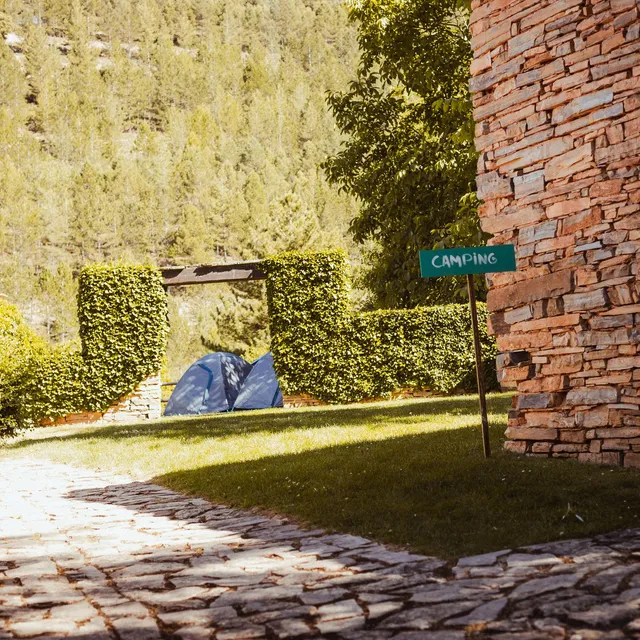 Entrada a la zona de camping desde la calle empedrada del pueblo