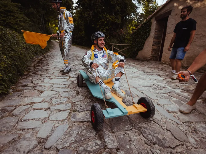 Carrera de carros de madera por la calle empedrada