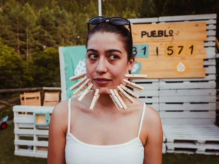Una chica con la cara llena de pinzas frente al marcador