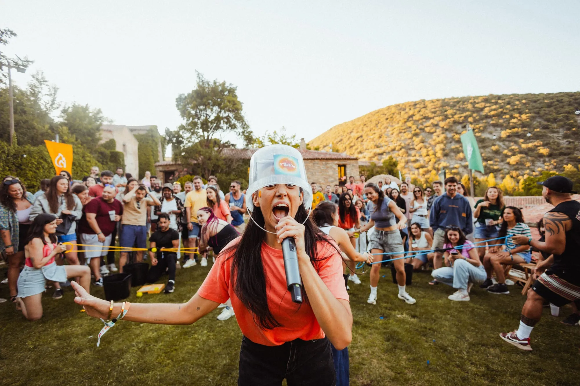 Una chica canta con micrófono y gorro de pescador delante de todo el público en la plaza de PUEBLO