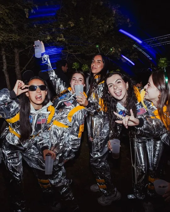 Un grupo con trajes plateados de astronauta posando en la fiesta del jueves