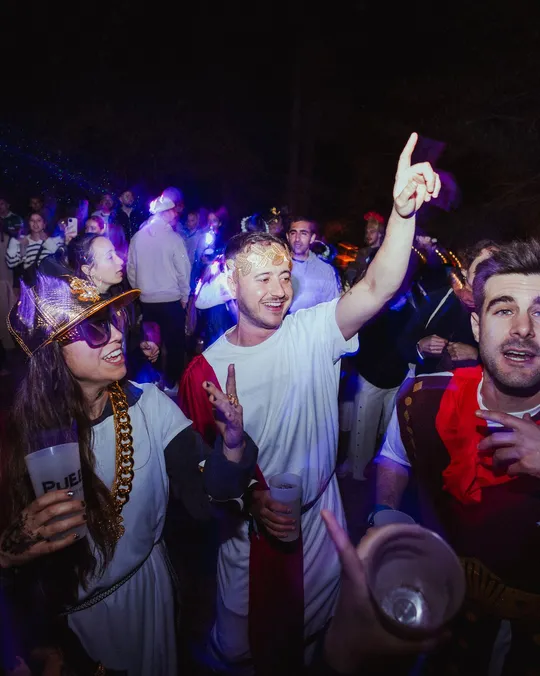 Gente disfrazada de romanos bailando en la fiesta temática