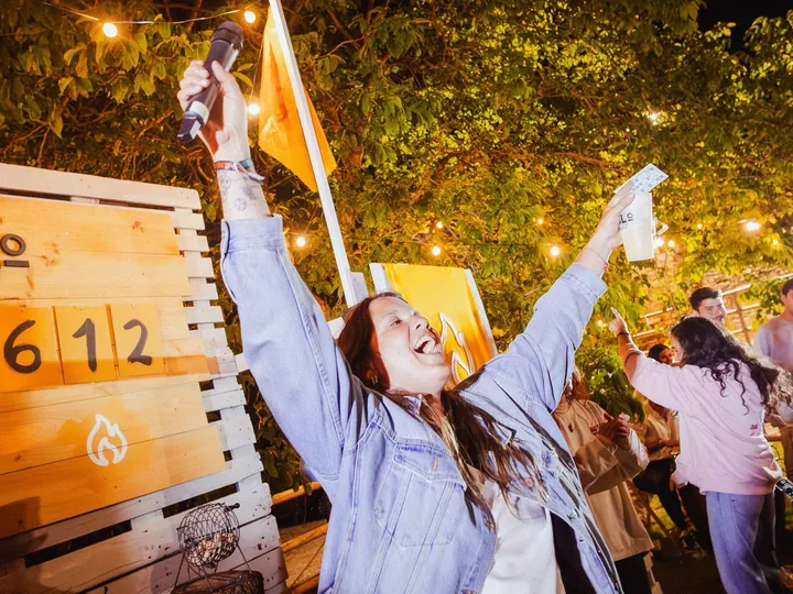 Una chica celebra de noche frente al marcador