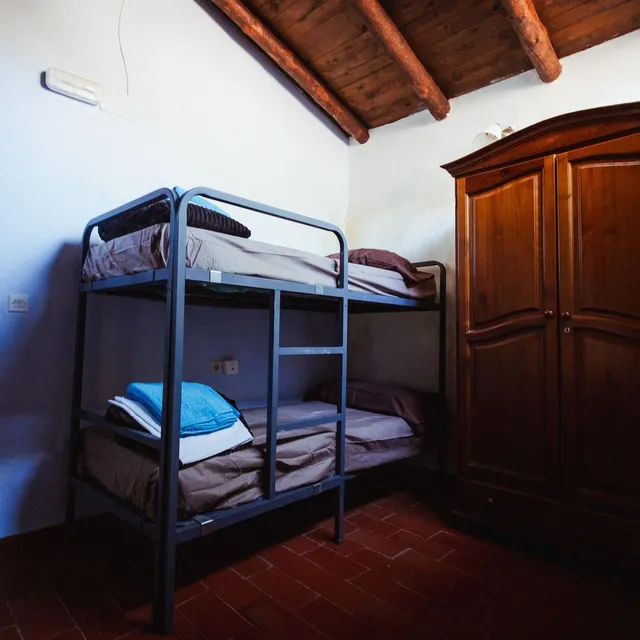 Habitación con litera y un armario antiguo de madera