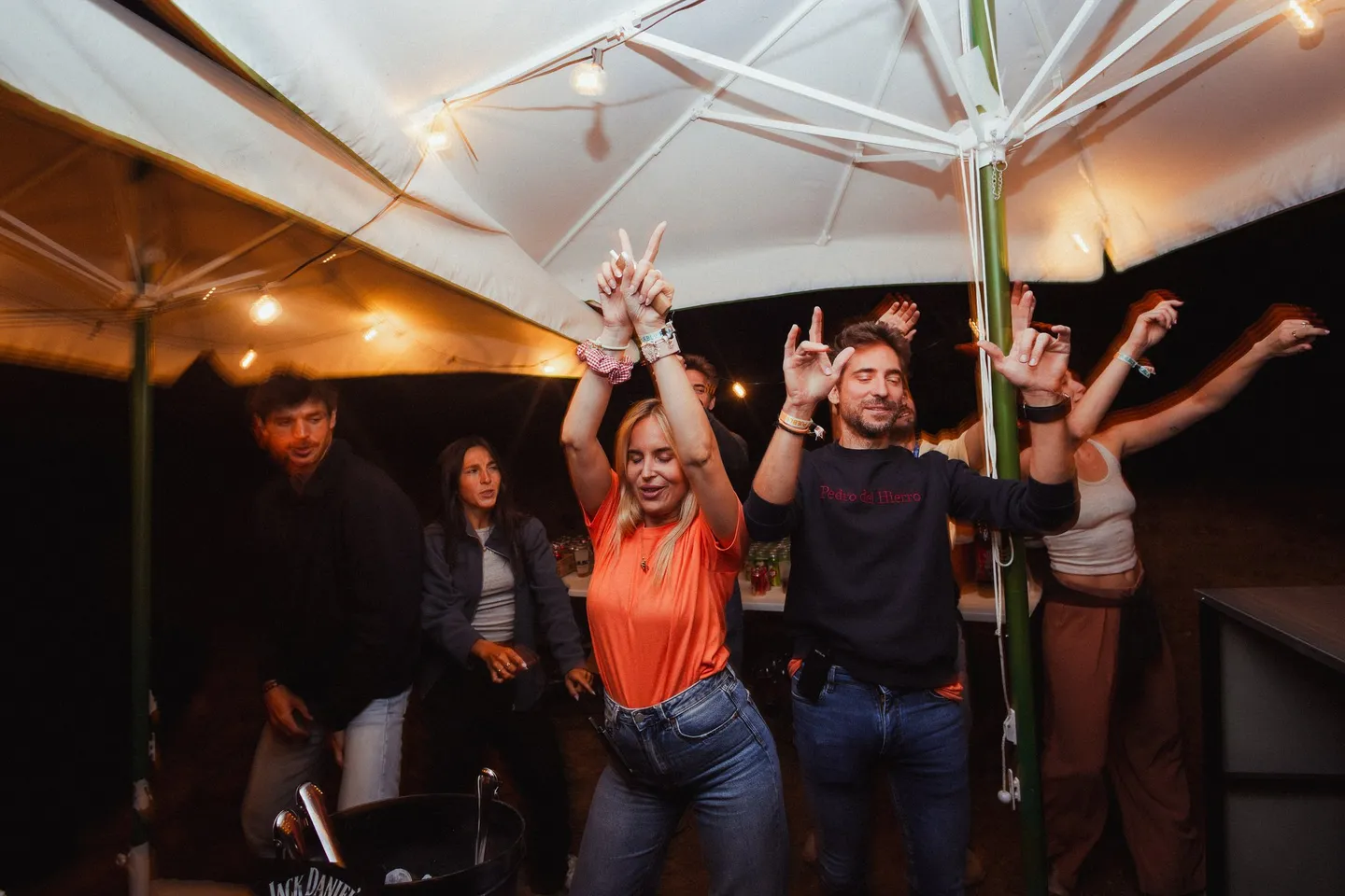 Gente bailando bajo la carpa en la fiesta del sábado por la noche en PUEBLO Fest Camp