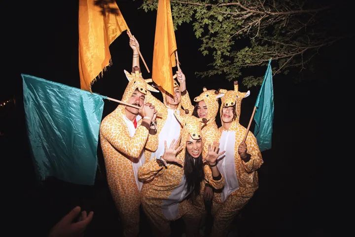 Un grupo disfrazado de jirafa posa con las banderas en la fiesta del viernes