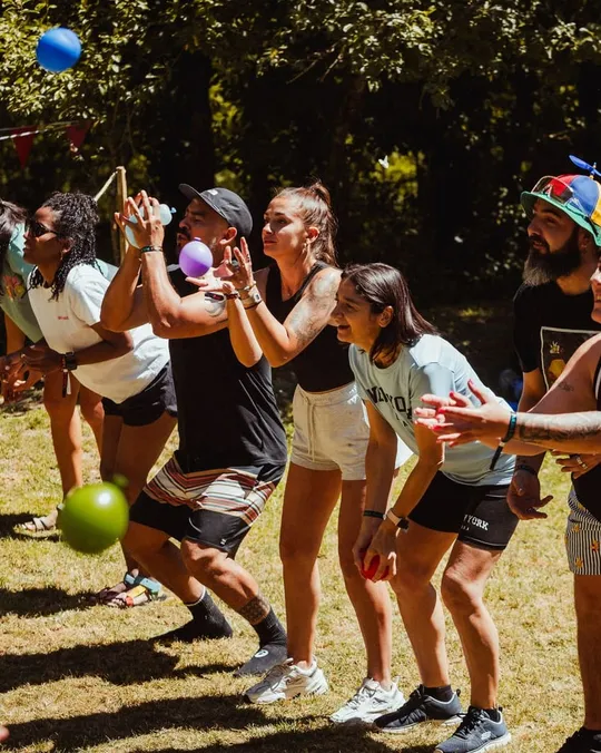 Juego por equipos en el césped: corren con globos entre las piernas