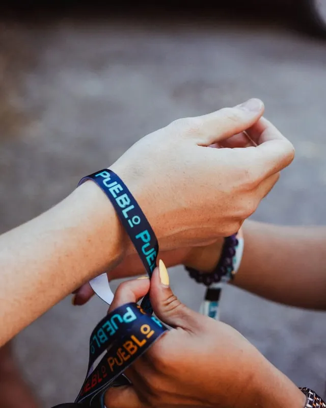 Una chica se pone la pulsera de Pueblo al llegar