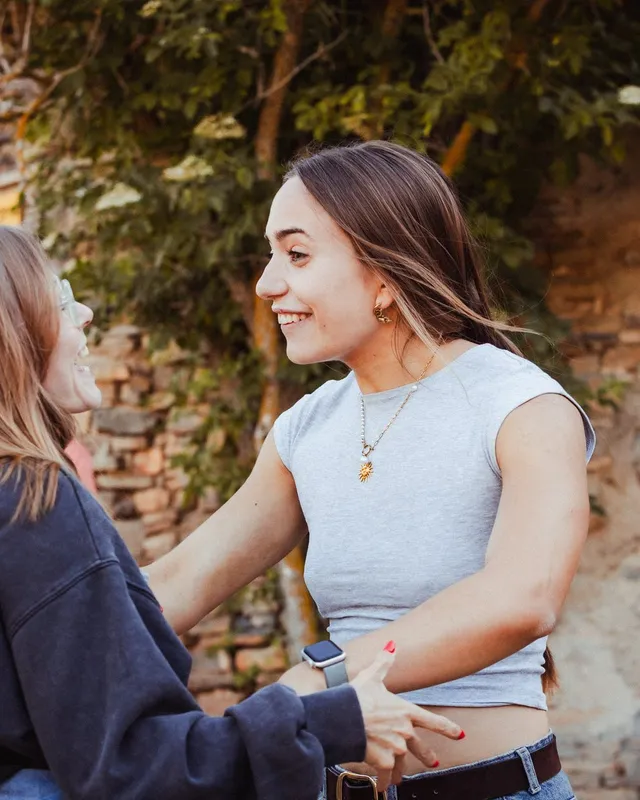Dos chicas se saludan sonriendo nada más llegar al pueblo
