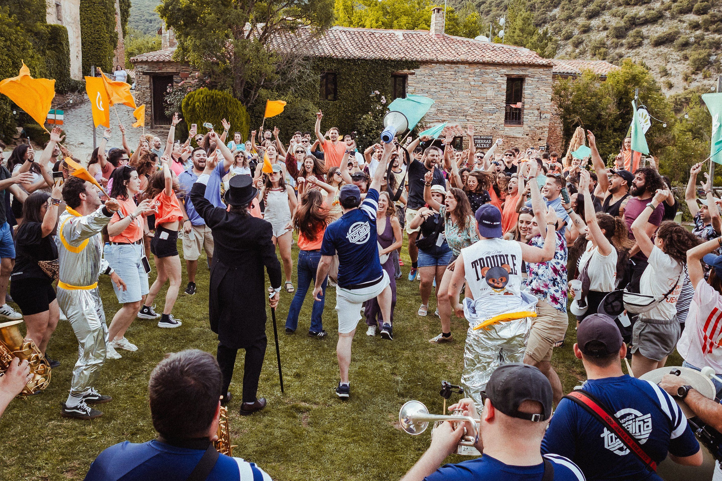 La plaza de Valdelavilla llena de gente bailando y animando a pleno día durante PUEBLO Fest Camp