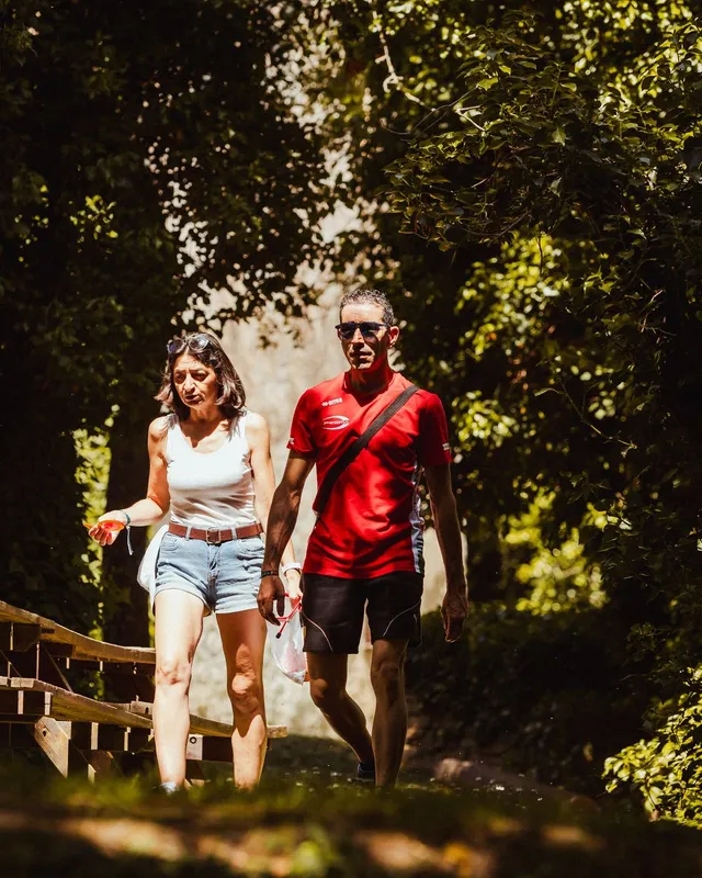 Una pareja camina por un sendero a la sombra del bosque de Valdelavilla