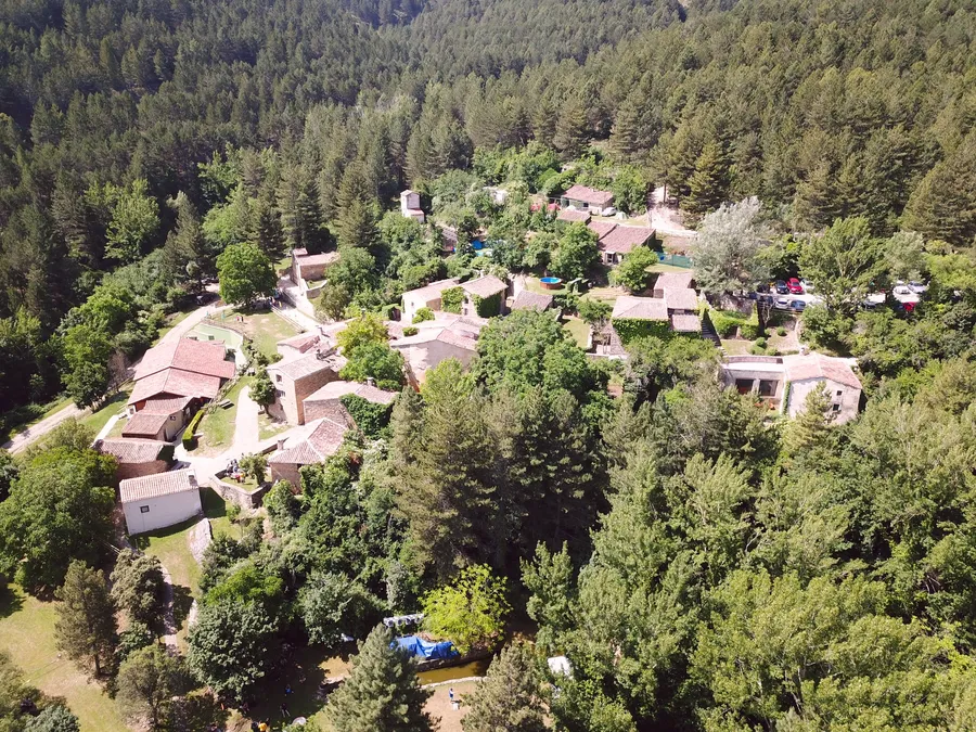 Valdelavilla desde el aire: casas de piedra y tejados rojos en medio del bosque