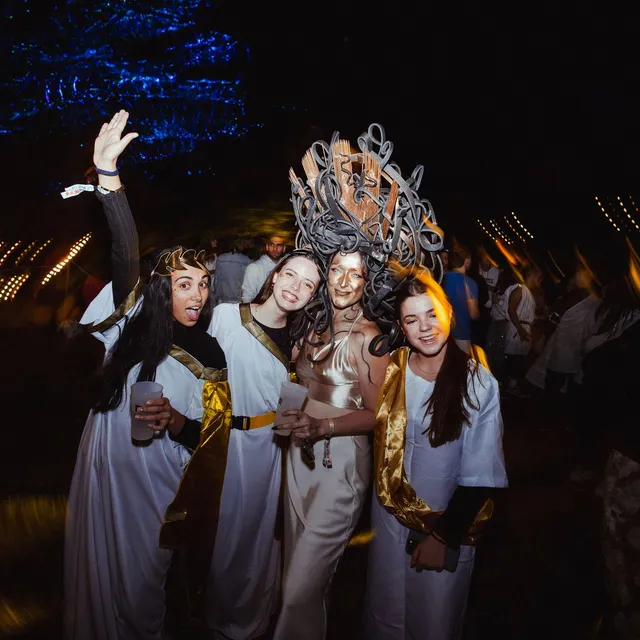 Un grupo de amigas con túnicas blancas celebra en la fiesta romana del viernes